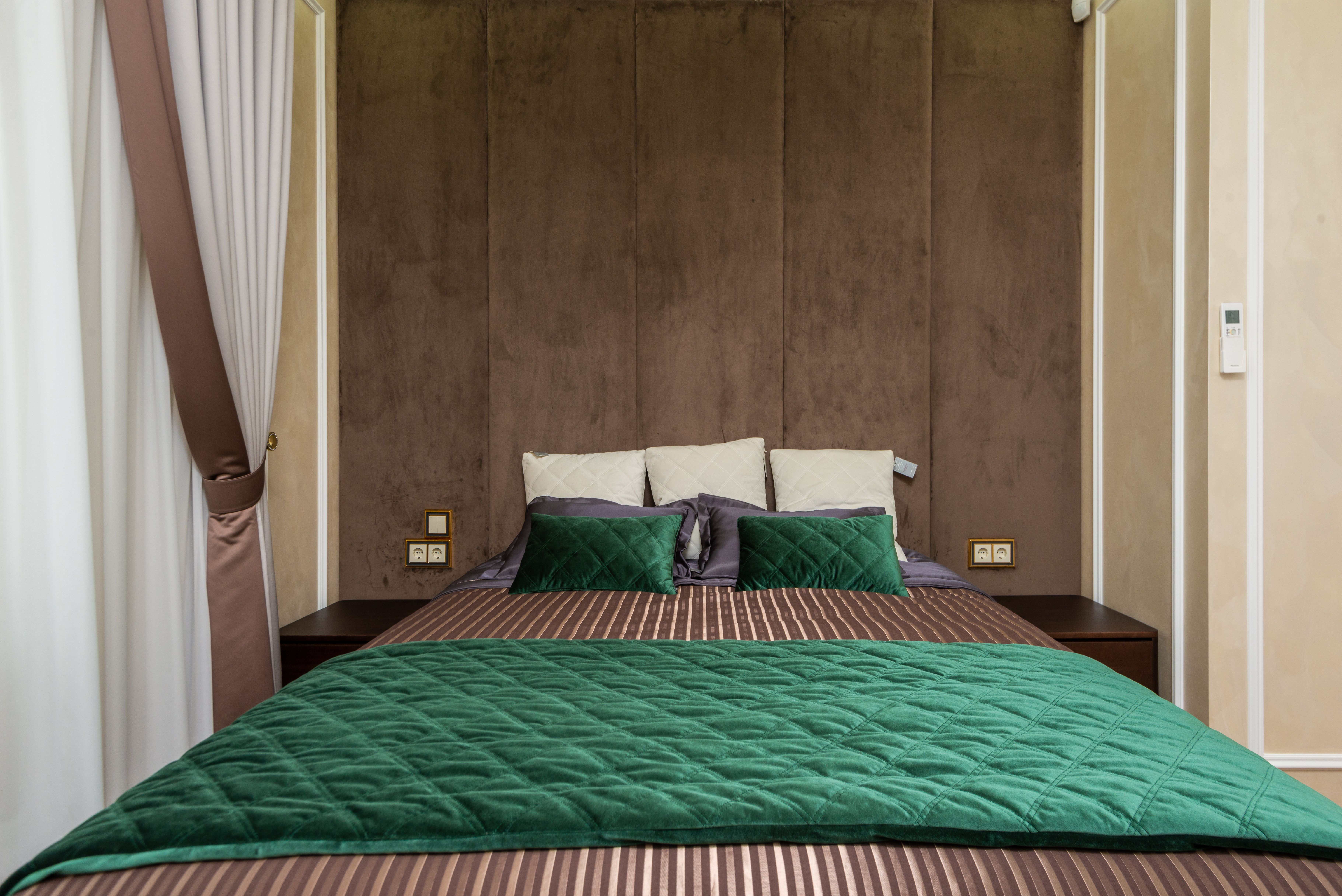 Quarto aconchegante decorado com cama e cabeceira estofada