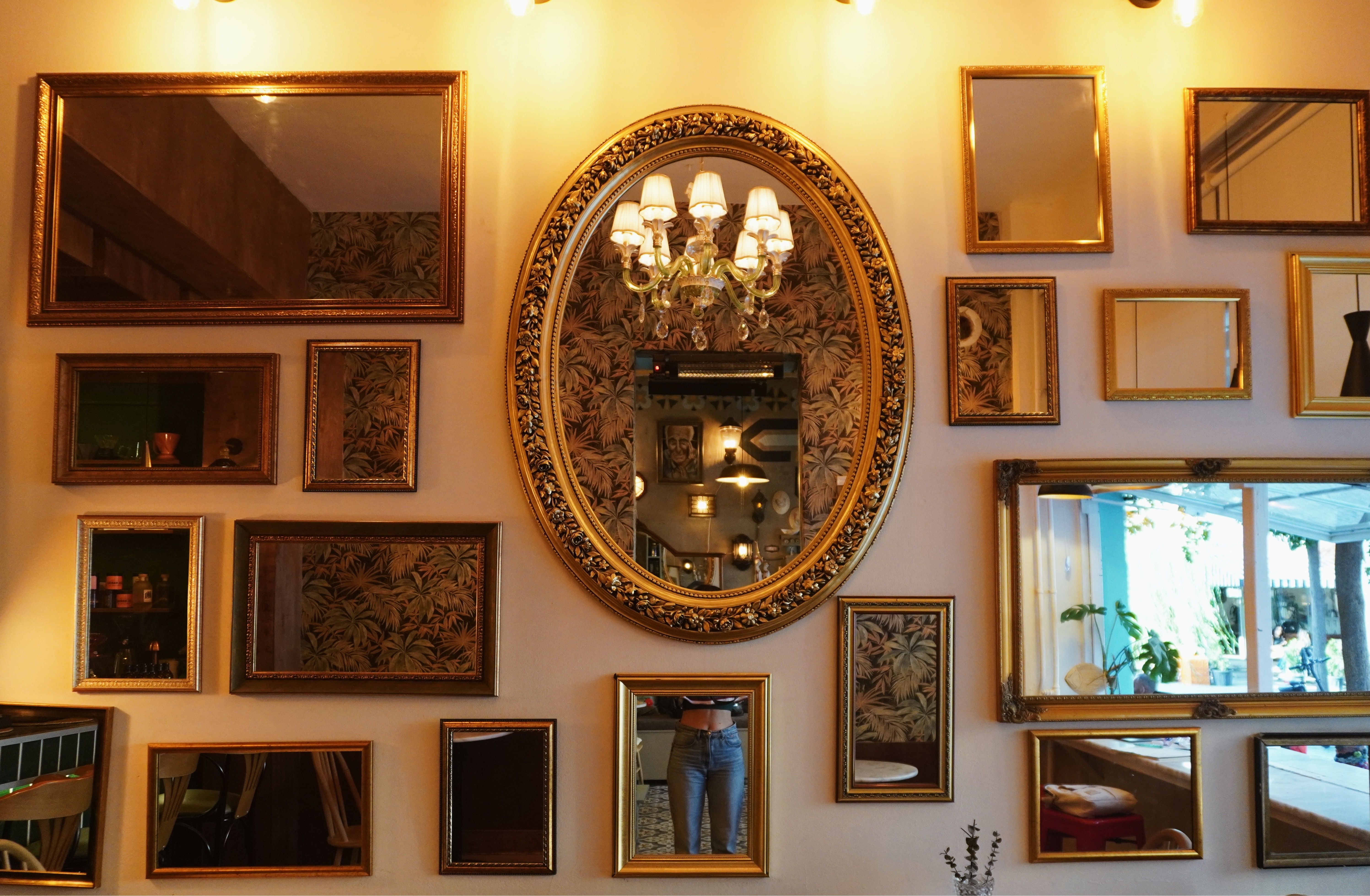 Espelho decorativo com moldura dourada envelhecida na parede
