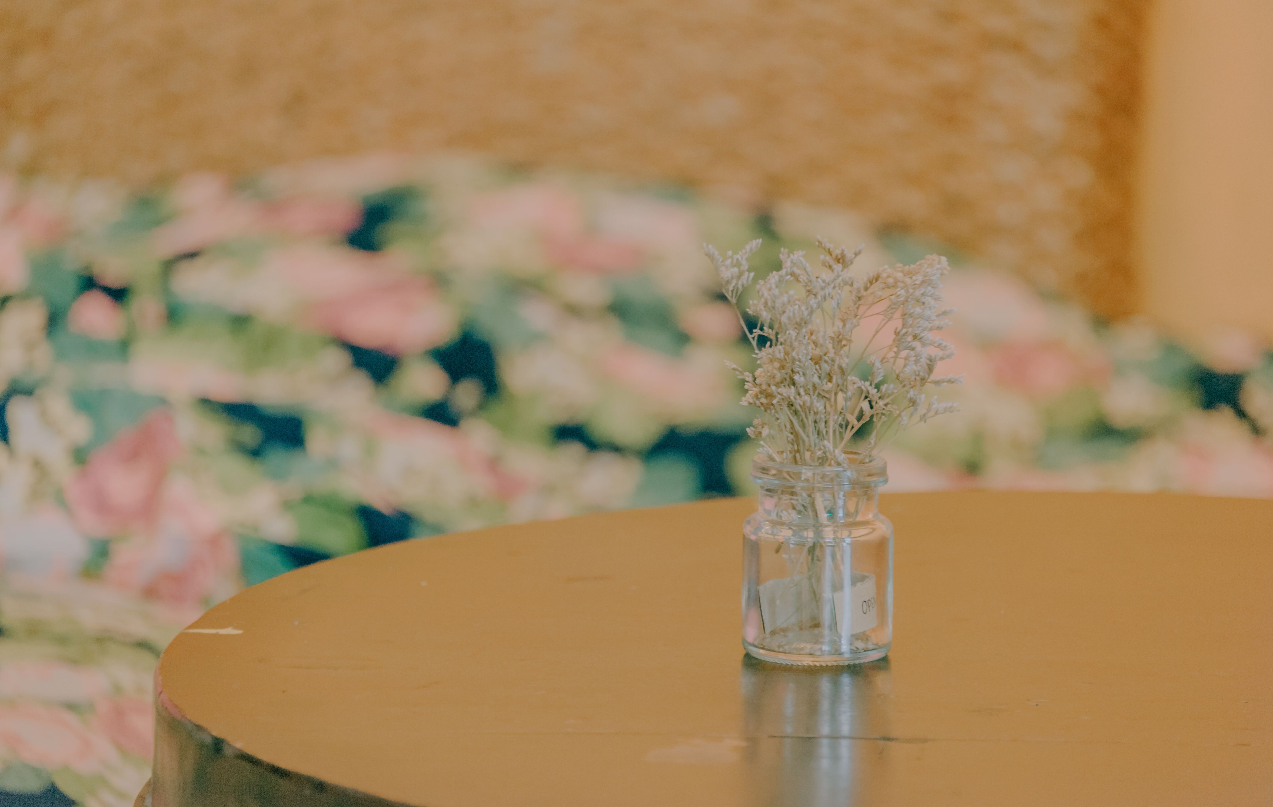 Vaso com flores secas sobre mesa de madeira