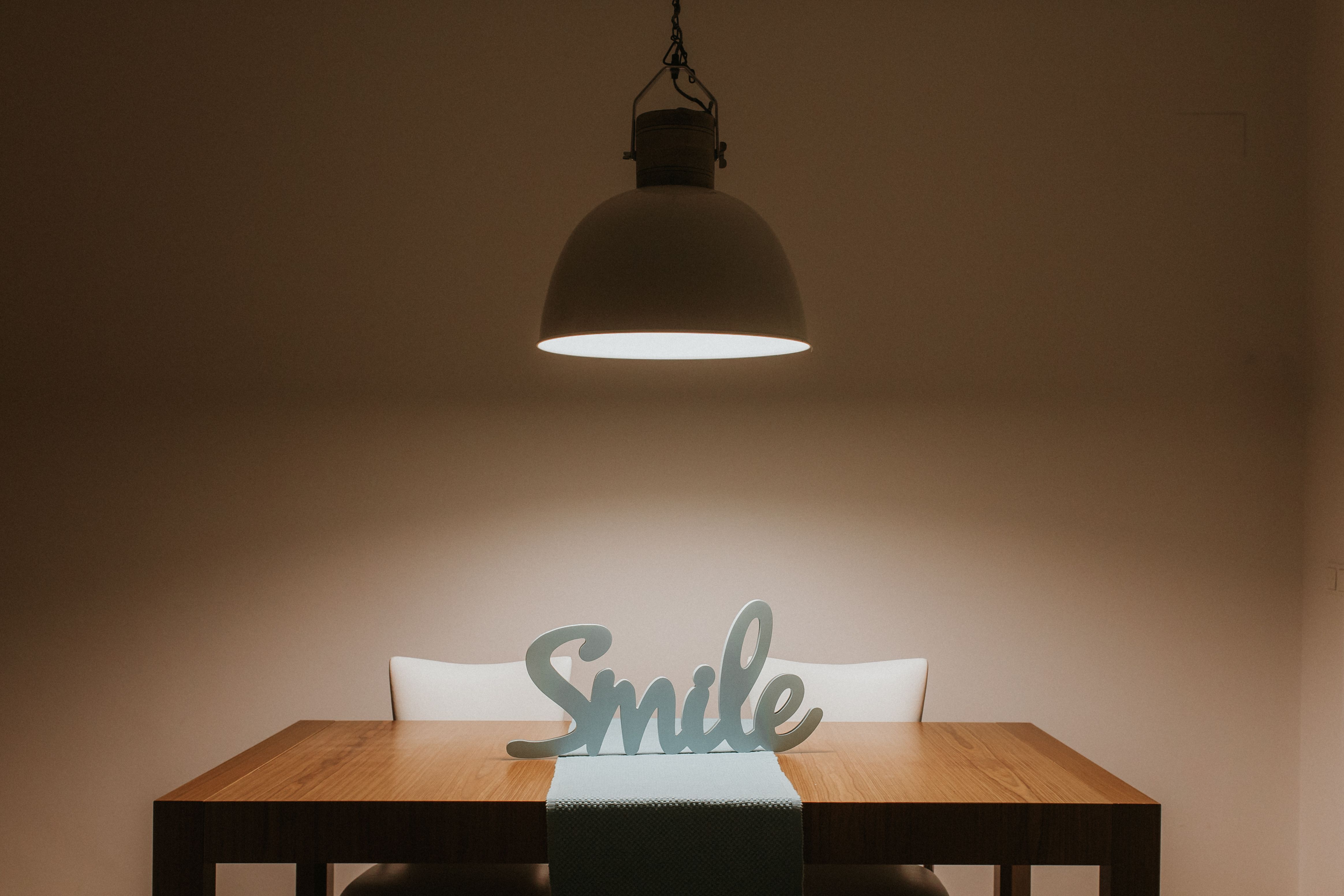 Luminária pendente sobre mesa de jantar em ambiente decorado