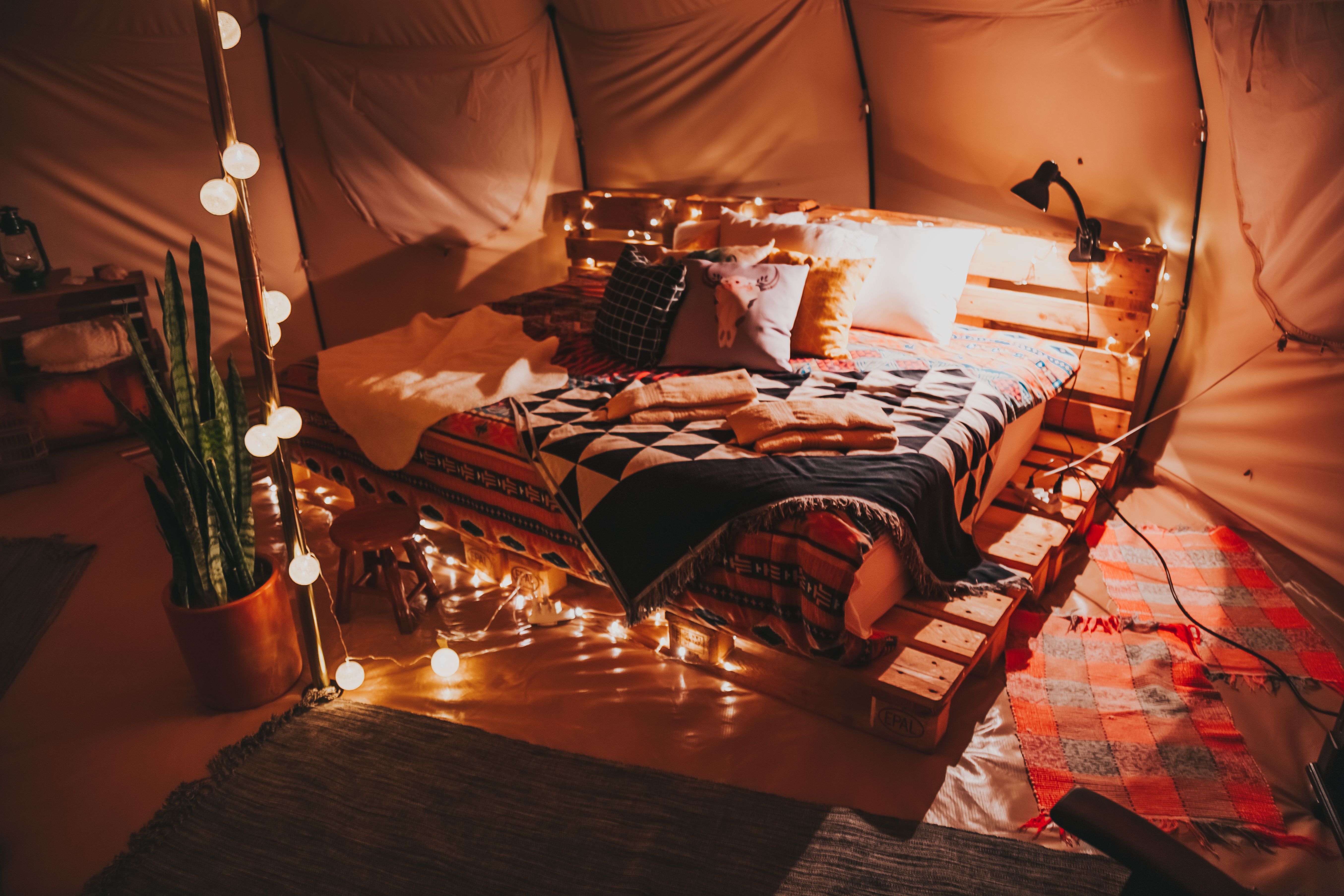 Cabeceira de cama feita com pallets de madeira no quarto