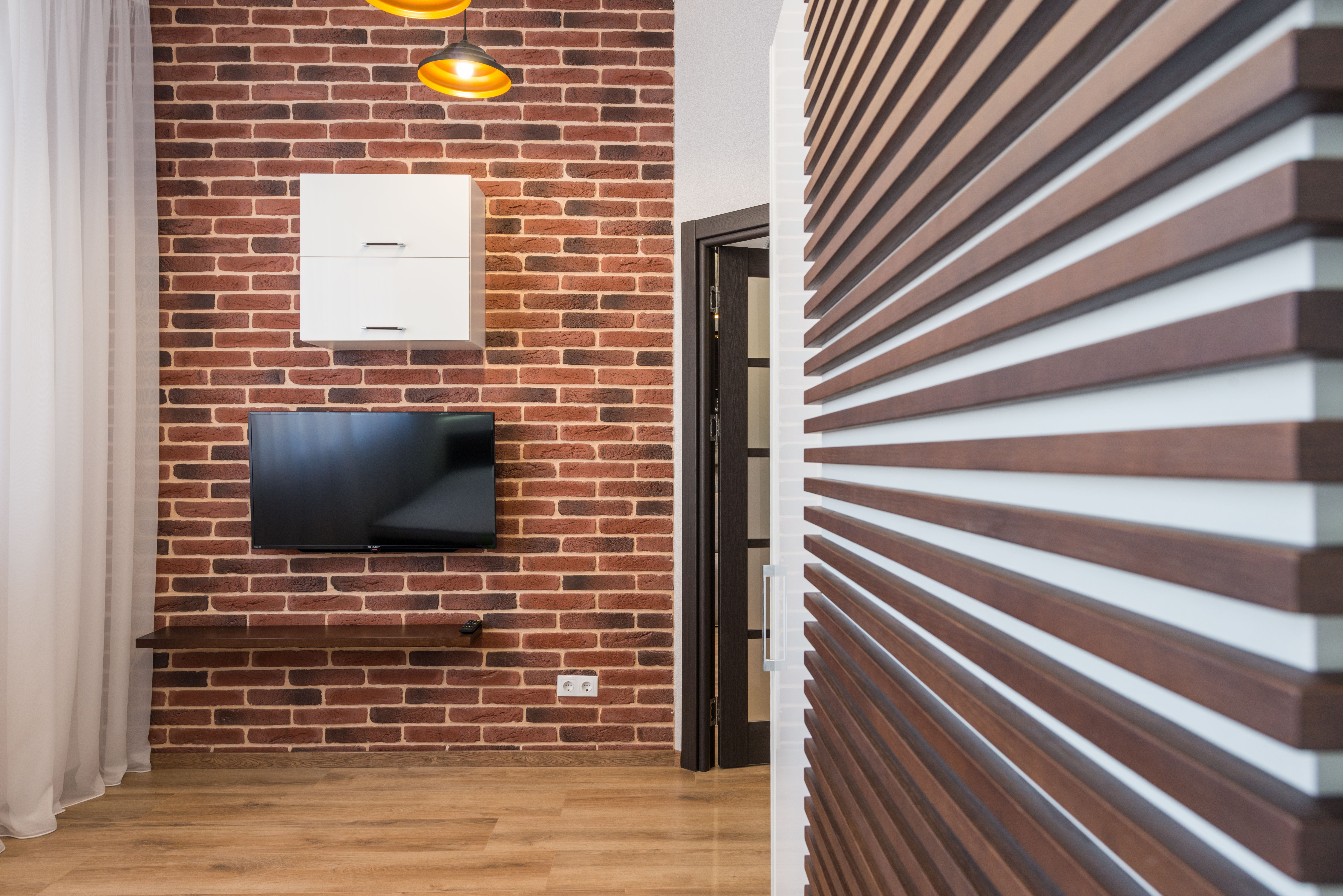 Sala de estar com painel de ripas de madeira atrás da televisão