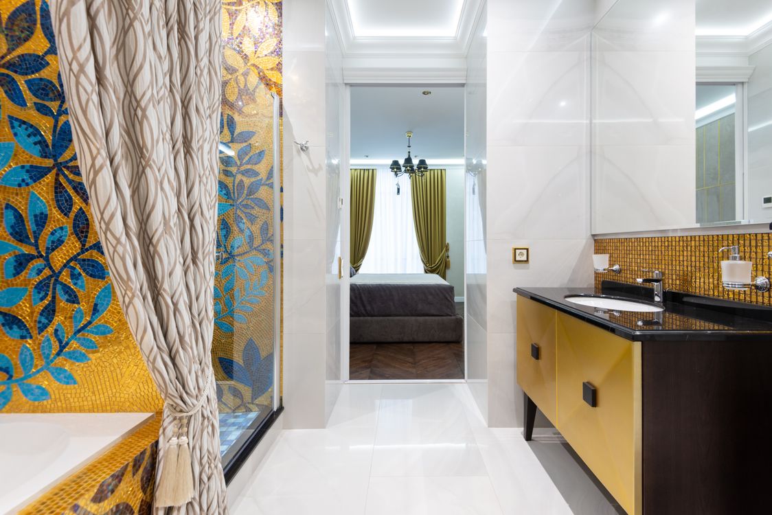 Luxury bathroom with mosaic art leading to a cozy bedroom, showcasing modern int