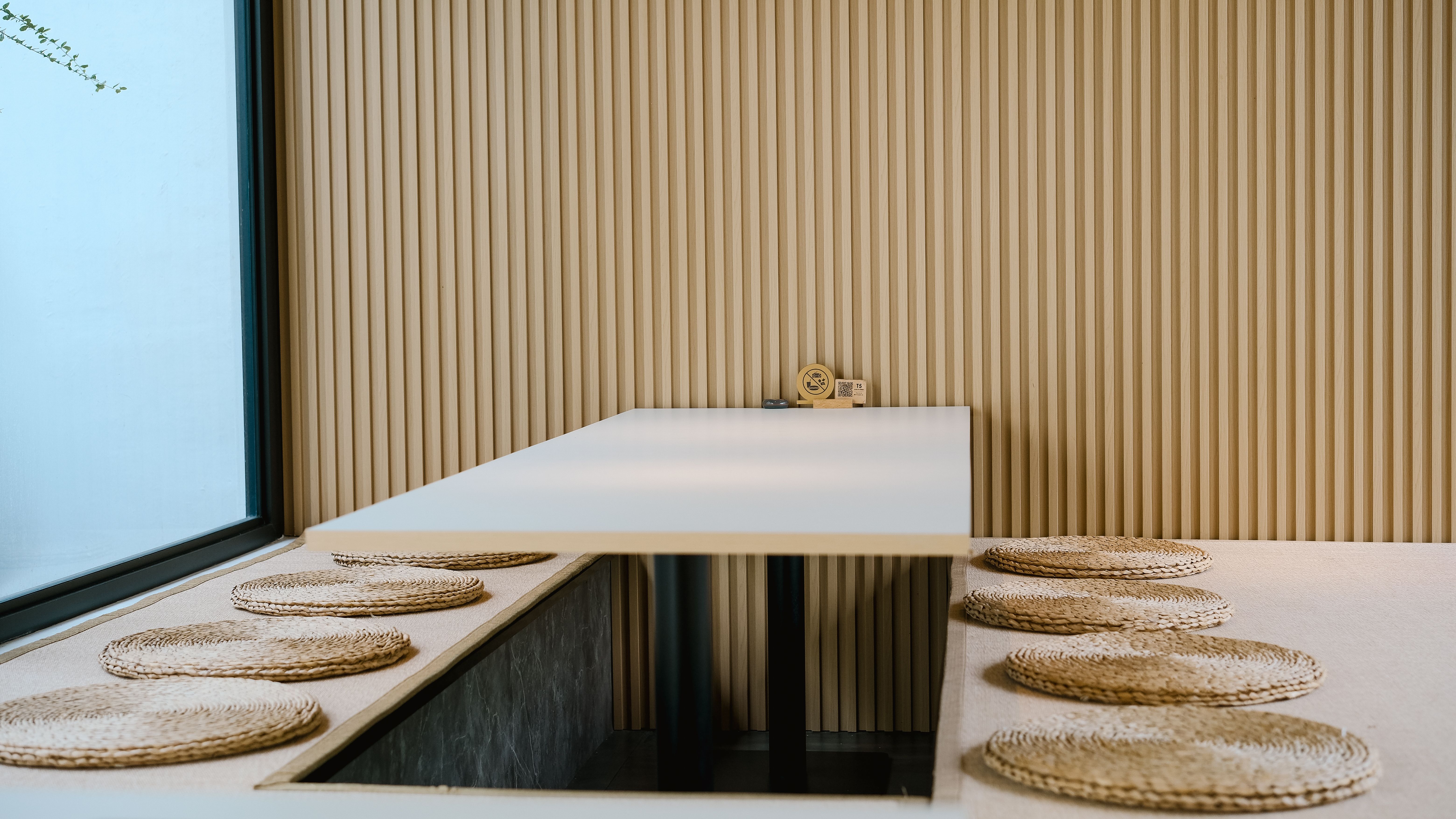 Sala de jantar minimalista de inspiração japonesa com tons neutros e esteiras naturais