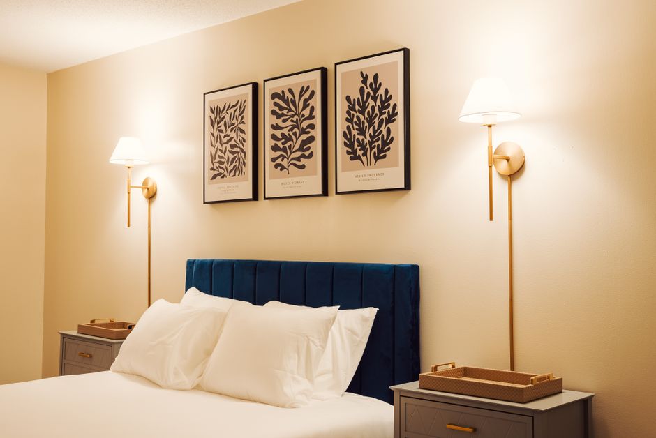 Quarto de hotel com arandelas de parede em diferentes formatos