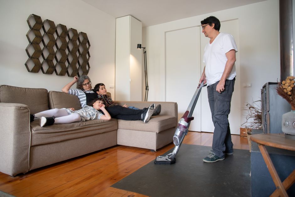 Pessoa usando aspirador de pó portátil na sala de estar