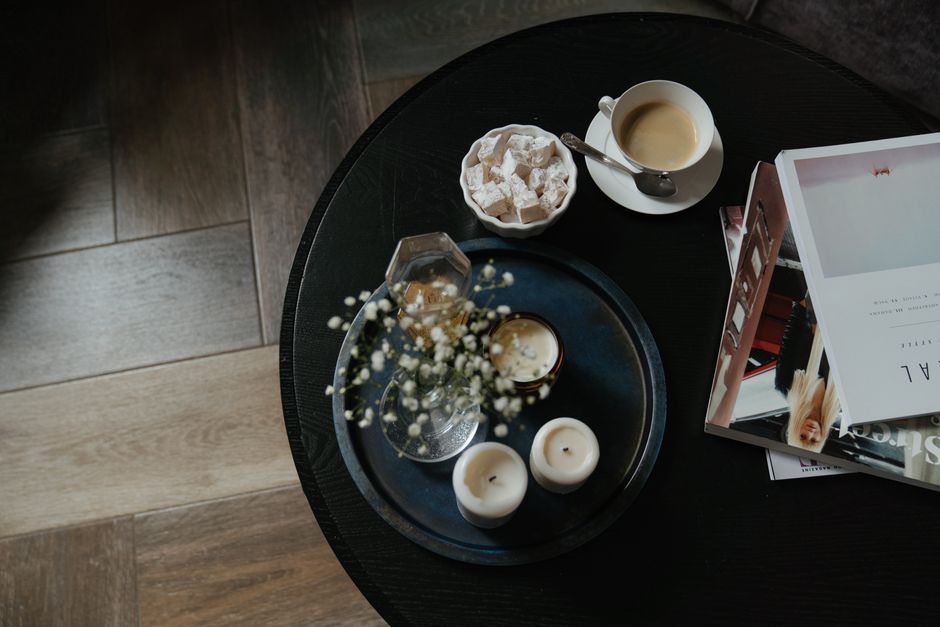 Composição de vela e objetos decorativos sobre bandeja em mesa de centro