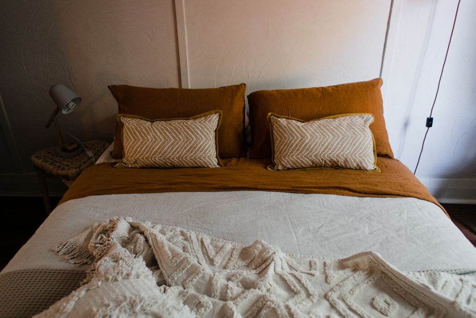 Quarto aconchegante com roupa de cama neutra bem cuidada