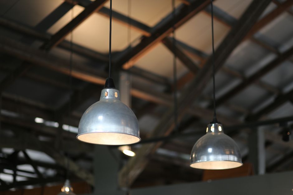 Luminárias industriais penduradas em ambiente estilo galpão