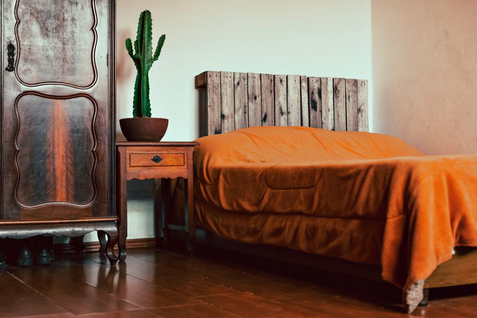 Quarto em tons terrosos com iluminação suave e materiais naturais