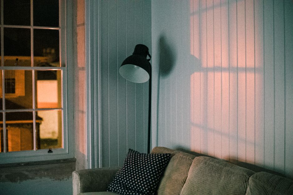 Luminária de chão com luz amarela aconchegante em sala à noite