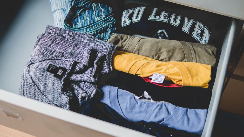 Pilha de roupas dobradas organizadas dentro de um armário