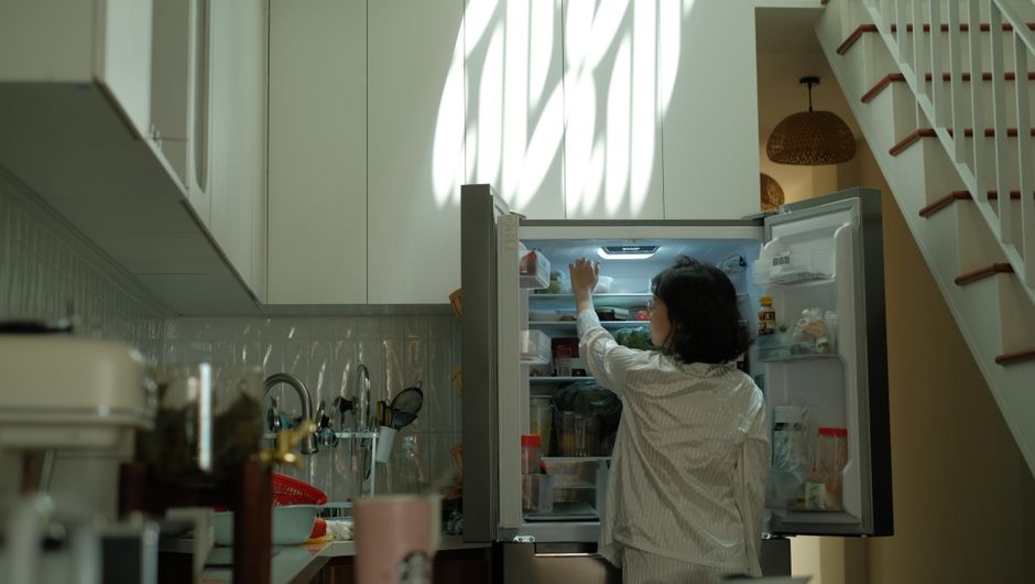 Pessoa organizando alimentos dentro da geladeira