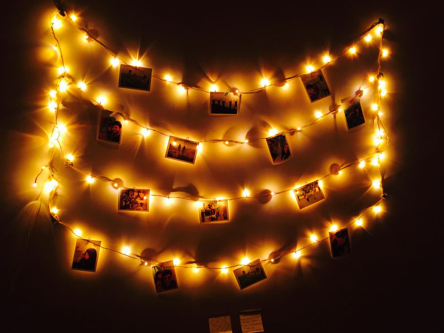 Molduras de fotos penduradas com luzes de LED formando um varal decorativo