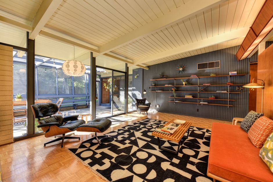 Sala de estar decorada no estilo mid-century modern com móveis de madeira