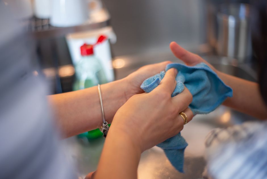Cozinha sendo limpa com produtos de limpeza sobre a bancada