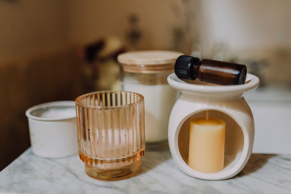 Arranjo de aromaterapia com velas e potes de vidro sobre mármore