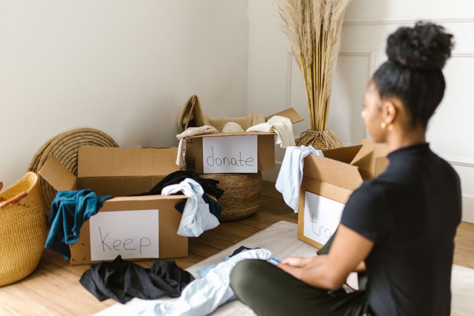 Pessoa sentada organizando itens ao lado de caixas de papelão