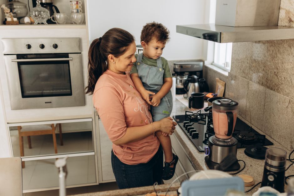 Mãe e filho preparando um smoothie juntos na cozinha de casa