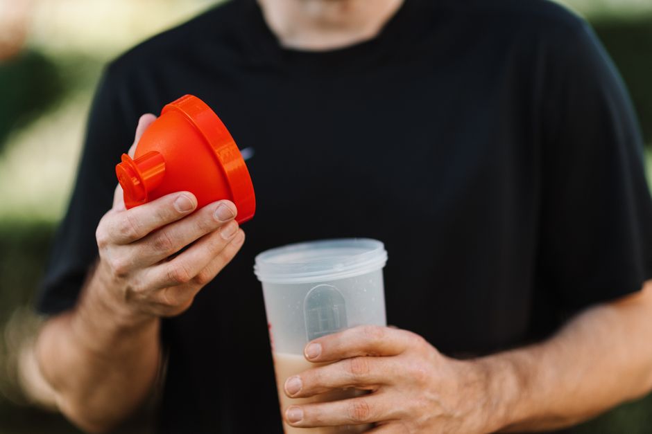 Pessoa segurando um copo portátil de liquidificador recarregável para levar