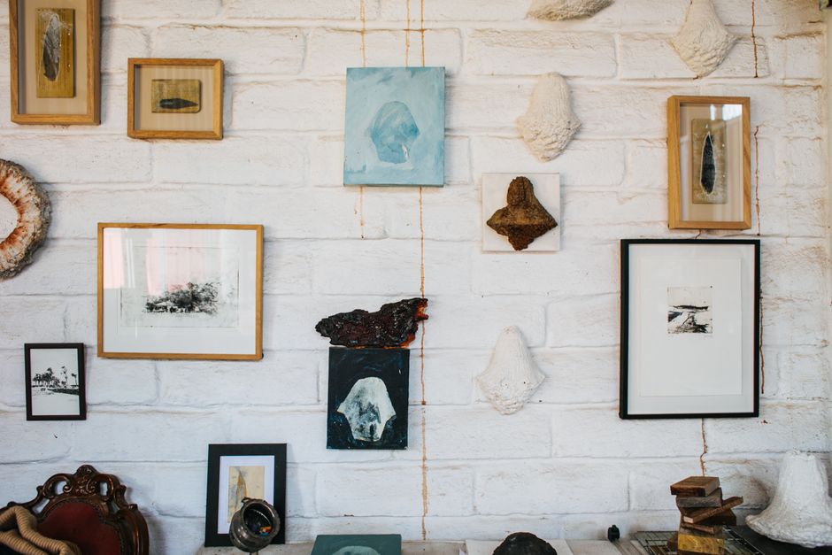 Parede de galeria com quadros e molduras em diferentes estilos