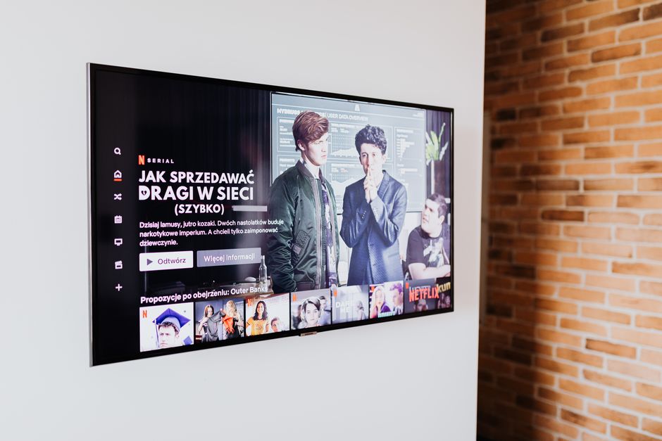 TV de tela plana fixada rente à parede branca em suporte fixo