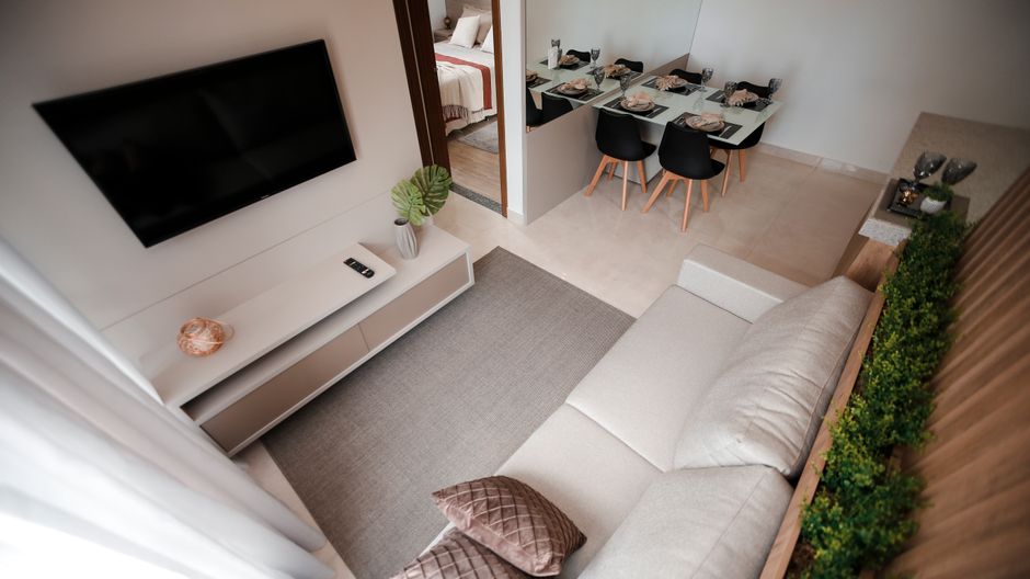 Painel de TV suspenso em MDF na parede de uma sala pequena