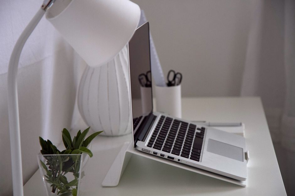 Setup minimalista de home office com suporte de notebook em alumínio