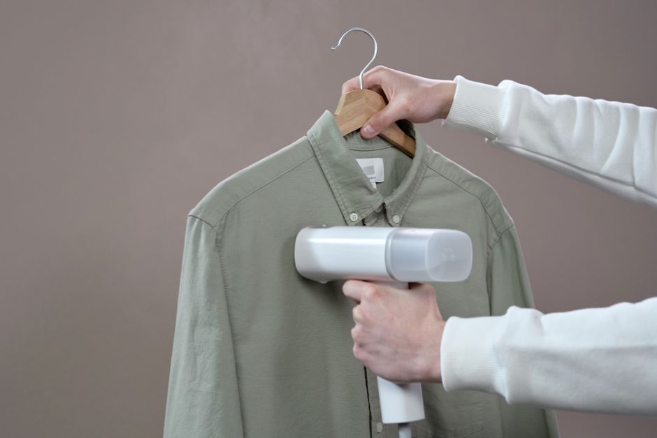 Detalhe do bico do vaporizador de roupas liberando vapor